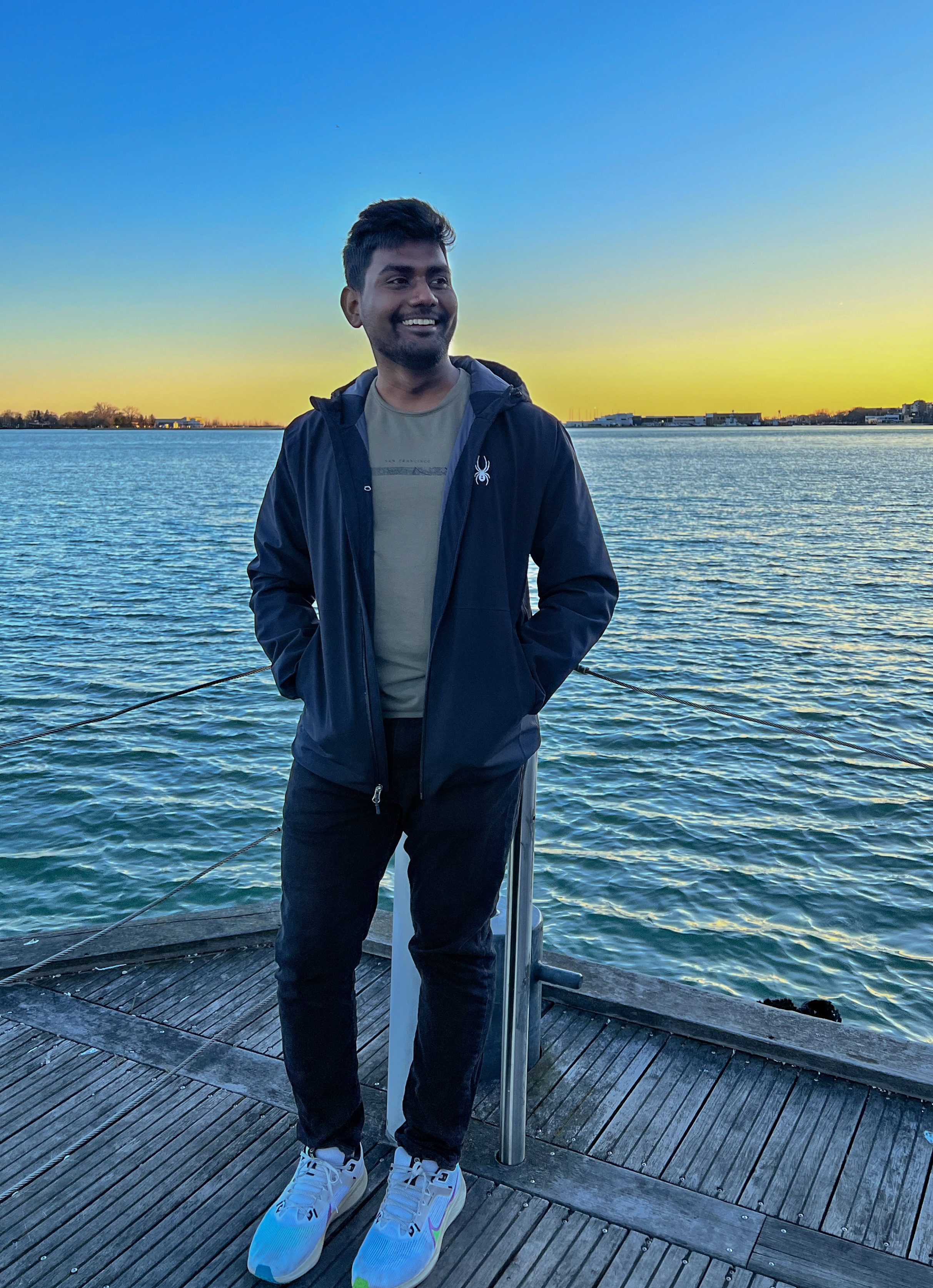 Siva standing on a waterfront at sunset in Vancouver